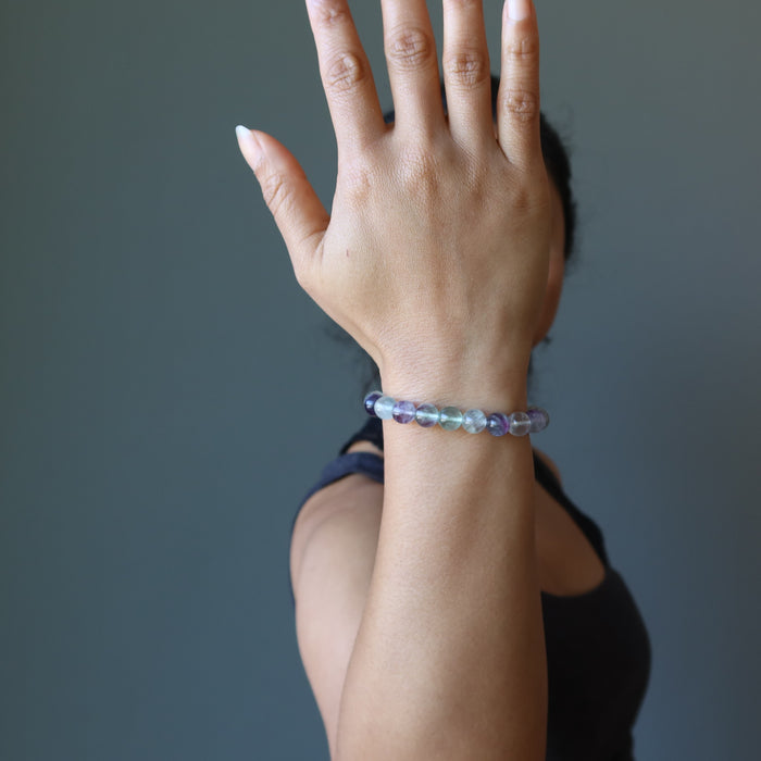 hand wearing a rainbow fluorite beaded stretch bracelet