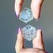 holding two Green fluorite hexagon cabochon crystals