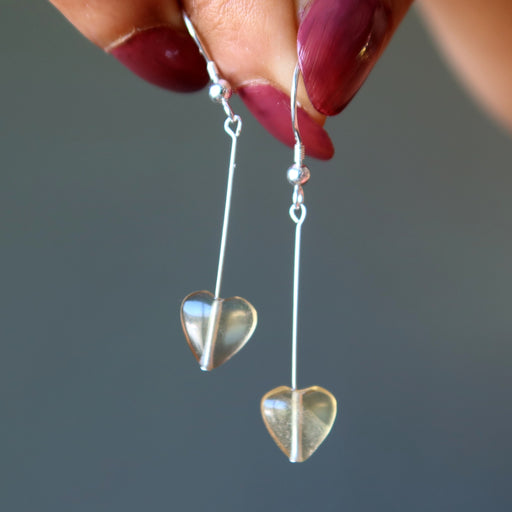 holding yellow heart fluorite earrings