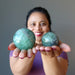 sheila of satin crystals holding 2 green Fluorite Spheres one on each palm