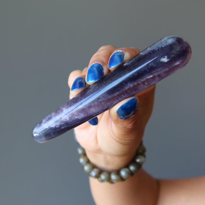 hand holding purple fluorite tapered massage wand