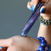 hand holding purple fluorite tapered massage wand at wrist