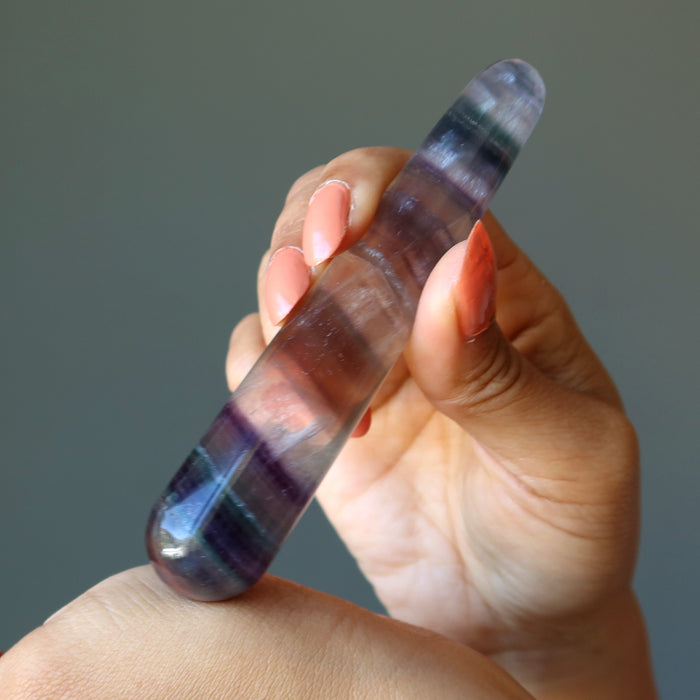 hand holding rainbow fluorite tapered massage wand