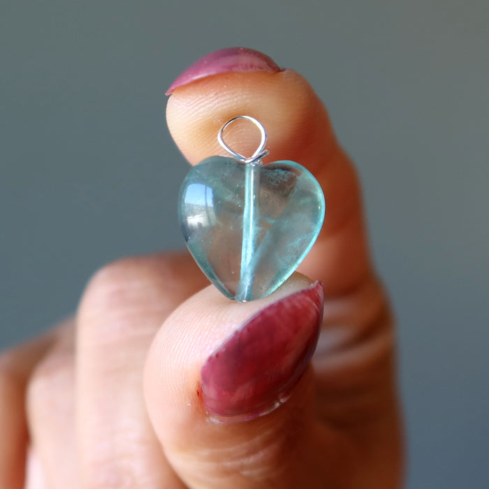 holding a blue Fluorite heart pendant