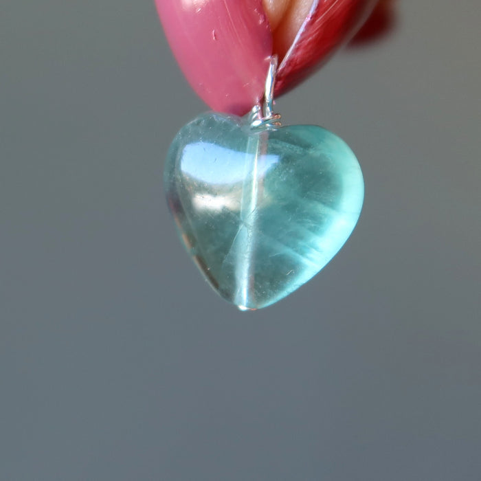 holding a blue fluorite heart pendant
