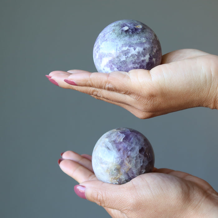 holding 2 Lavender Fluorite Spheres one on each hand