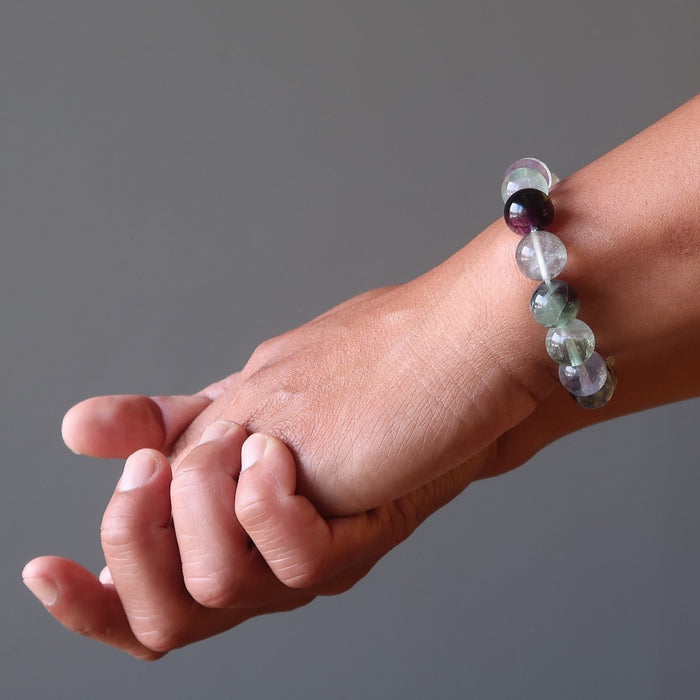 man's hand wearing rainbow fluorite beaded stretch bracelet 
