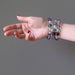 hand wearing 3 rainbow fluorite beaded stretch bracelets