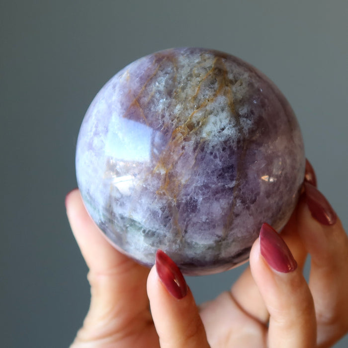 holding purple rainbow Fluorite Sphere