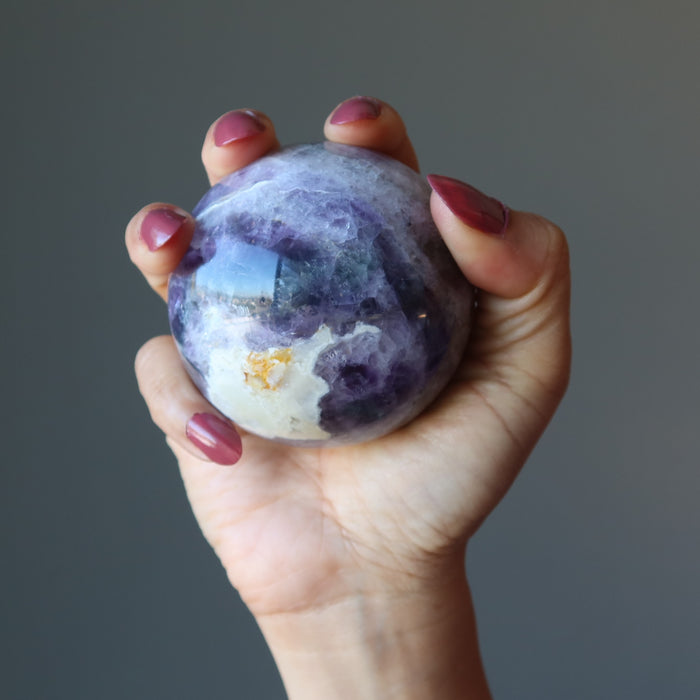 holding purple rainbow Fluorite Sphere