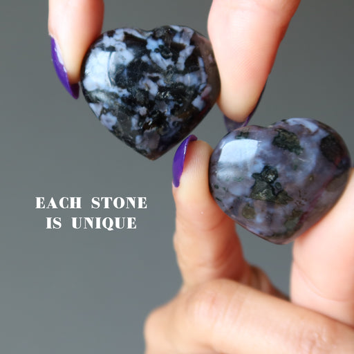 holding two Gabbro Hearts with fingers on each hand