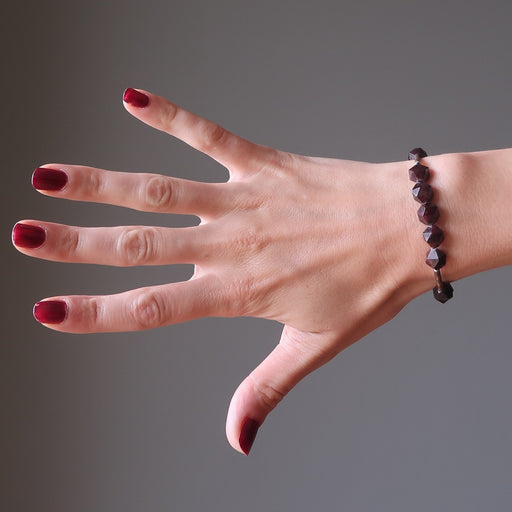hand wearing faceted garnet bracelet
