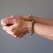two hands posing wearing green garnet bracelets