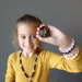 female child holding out raw green garnet