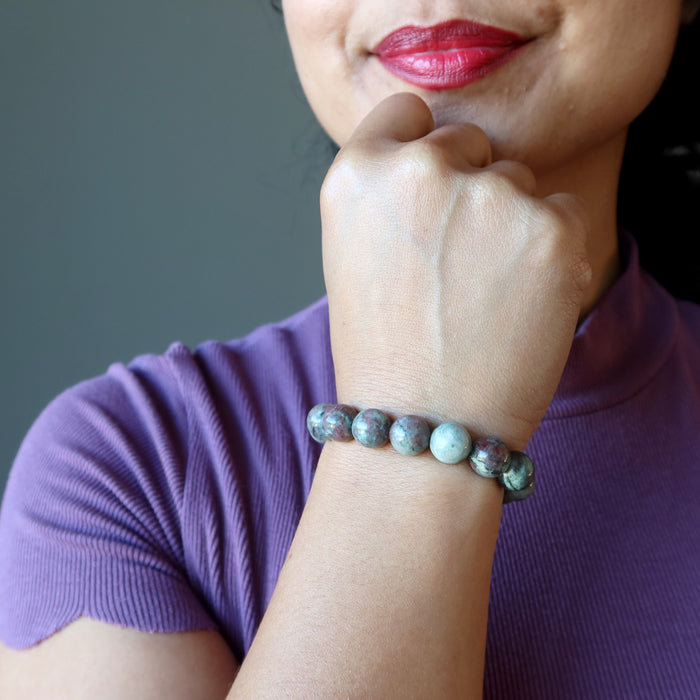 woman with hand on chin wearing kashgar garnet bracelet