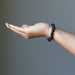 female hand wearing blue goldstone bracelet