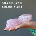 pair of rough pink rose quartz stones in hand