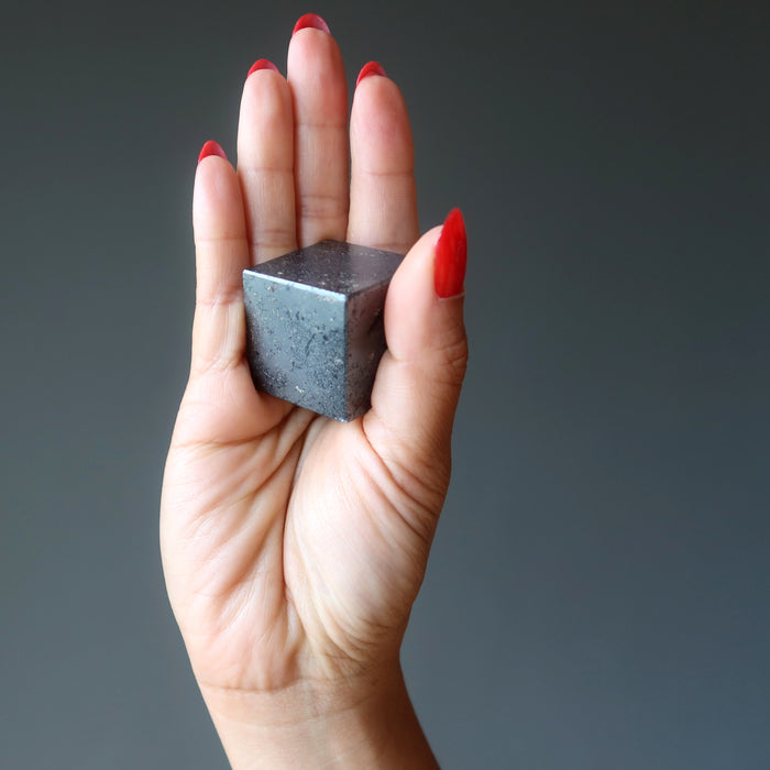 hematite cube in palm of hand