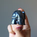 finger tips holding Hematite Elephant showing back side