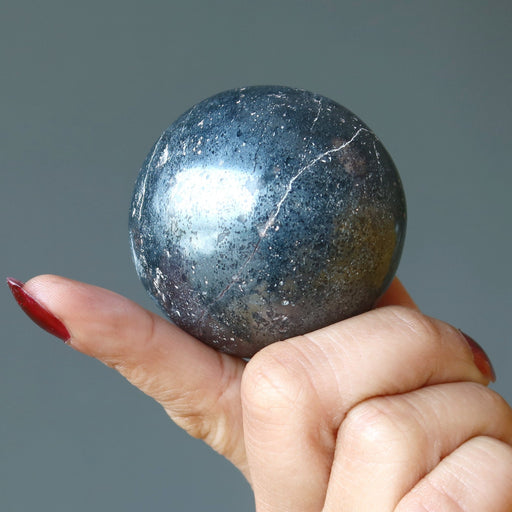 hand holding hematite sphere