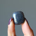 finger tips holding Hematite Tumbled Stone
