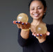 sheila of satin crystals holding out 2 golden calcite spheres