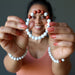 wearing Howlite Red Jasper Bracelet on each wrist and holding one in front