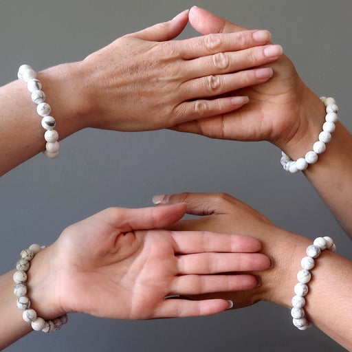 four hands all wearing howlite stretch bracelets
