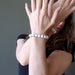 female with hands up in front fo her face modeling howlite stretch bracelets