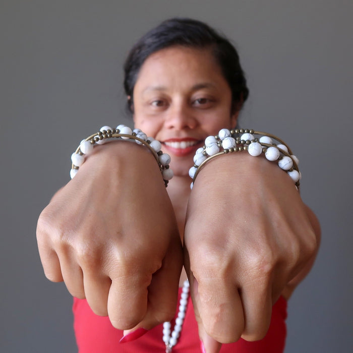 sheila of satin crystals with wrists extended wearing howlite coil bracelets