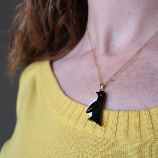 model wearing black onyx and white howlite penguin pendant on 14 karat gold necklace chain