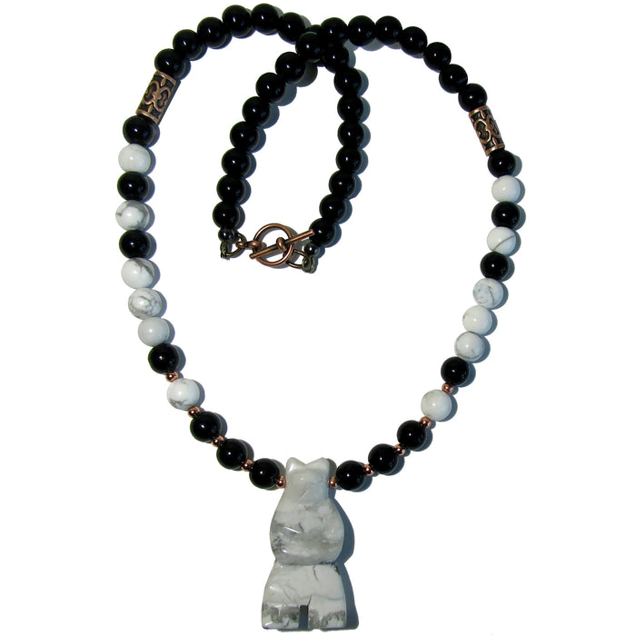 Round gray and white Howlite and black Obsidian beads and carved standing bear pendant strung with copper beads necklace wire. The necklace is secured with toggle clasp