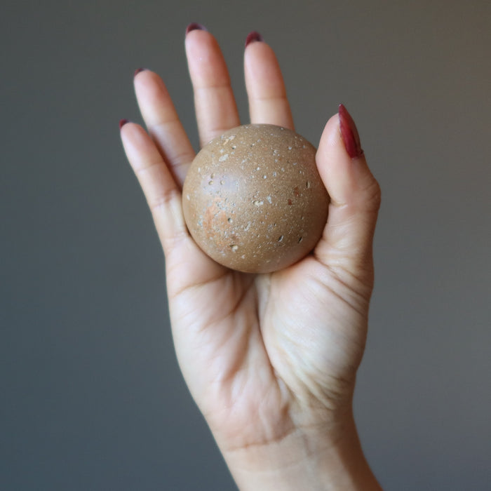 hand holding a brown ilyinets crater sphere