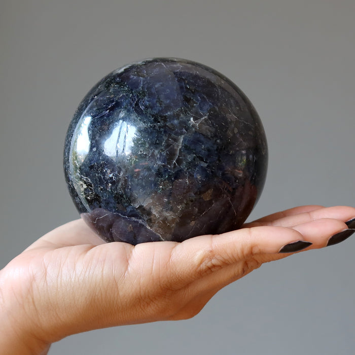 hand holding iolite sphere