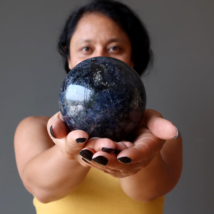 sheila of satin crystals holding an iolite sphere