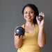 sheila of satin crystals holding two iolite spheres to show size difference