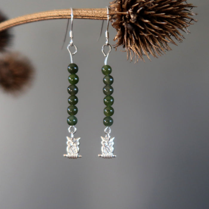 jade owl earrings hanging on a branch