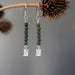 jade owl earrings hanging on a branch
