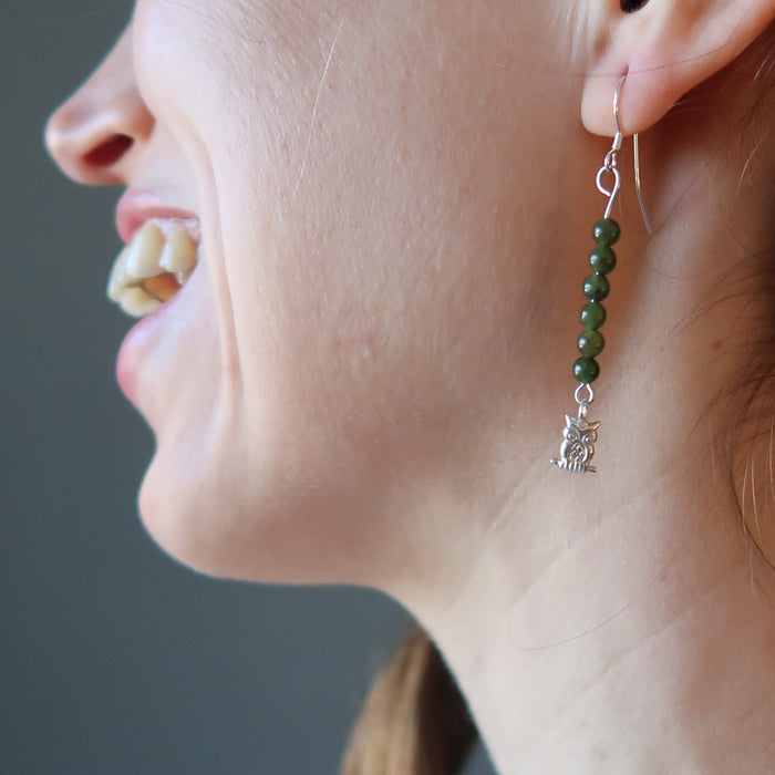 woman modeling jade owl earrings