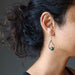 woman modeling jade earrings