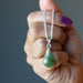 hand holding jade pendant on sterling silver chain