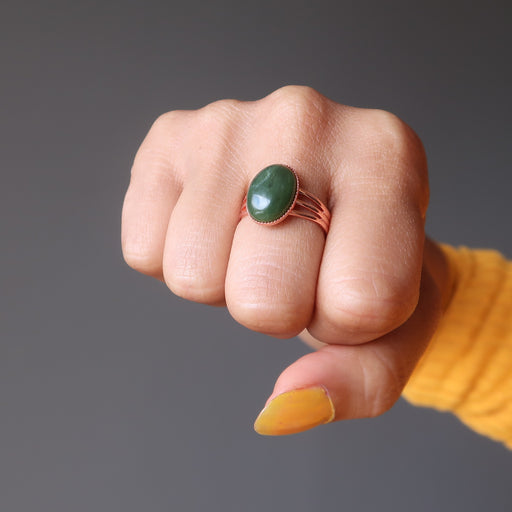 fist wearing green jade oval in copper adjustable ring