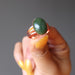 hand holding green jade oval in copper adjustable ring