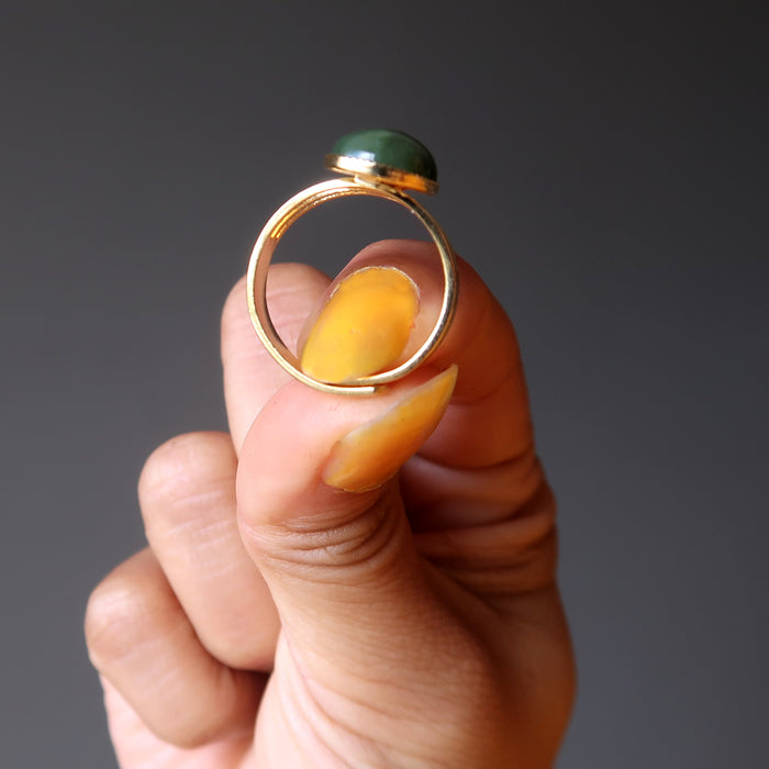 hand holding nephrite jade oval in gold adjustable ring