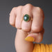 hand making fist wearing nephrite jade gold ring