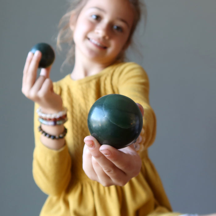 girl modeling holding dark green nephrite jade sphere
