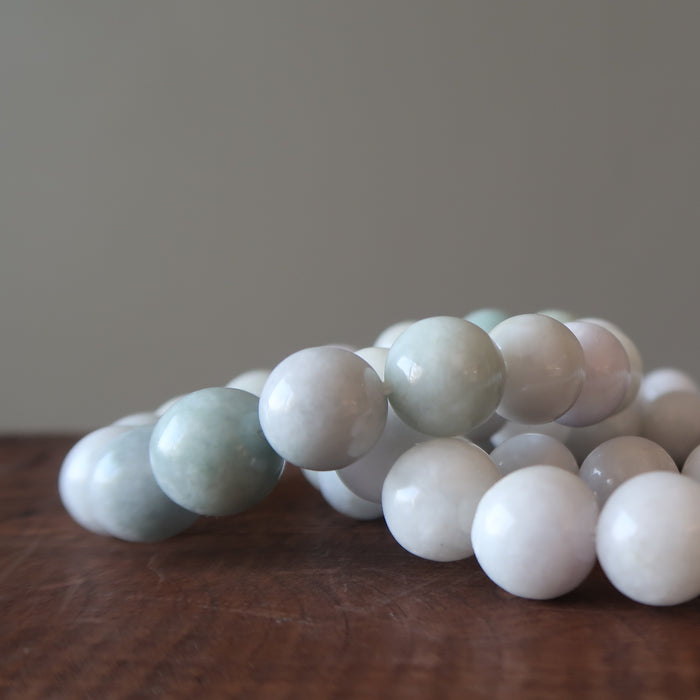 white jade round beaded stretch bracelet on table
