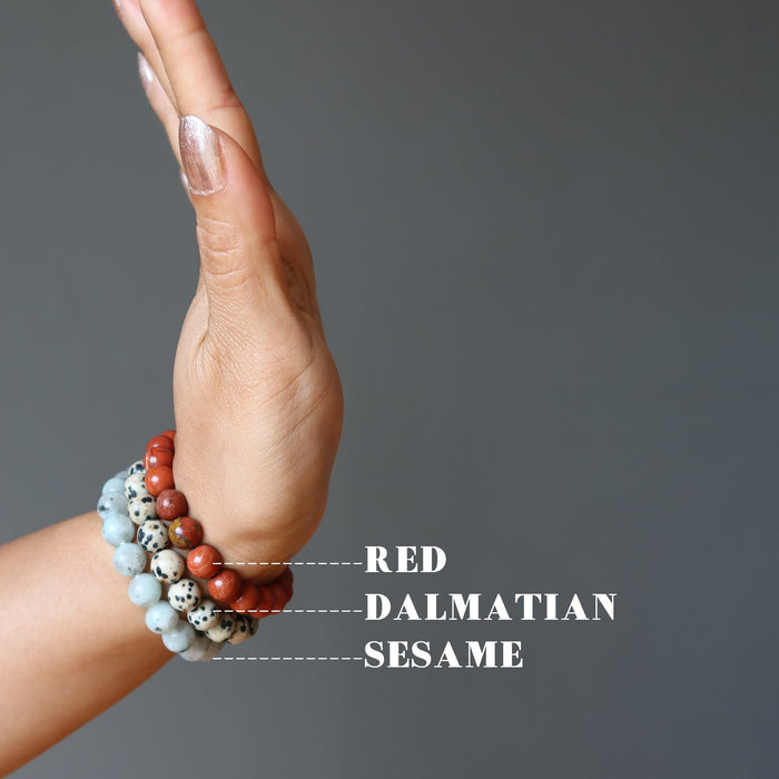 hand  wearing set of 3 sesame, red and dalmatian jasper stretch bracelets.