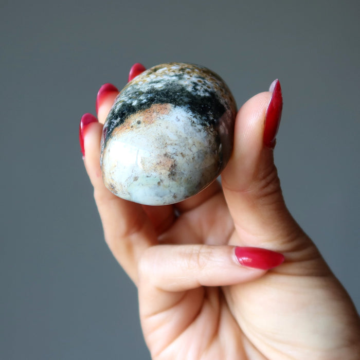 hand holding an ocean jasper oval stone