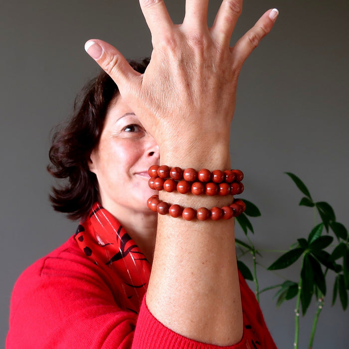 woman wearing three red jasper bracelets